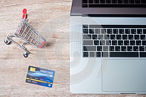 Shopping cart credit card and laptop at home office. business, e-business, technology, e-commerce, digital banking and online