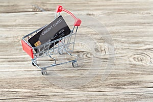 Shopping cart with credit card. Stay home shopping and electronic payment with credit card concept. Small shopping cart with credi