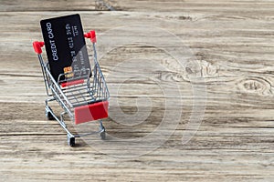 Shopping cart with credit card. Stay home shopping and electronic payment with credit card concept. Small shopping cart with credi