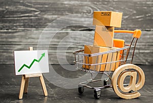 Shopping cart filled with boxes, email symbol and stand with green up arrow. shopping online. Growth rate of Internet sales