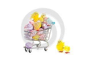 Shopping cart filled with colored easter eggs and happy colored easter chickens.