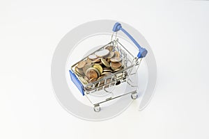 Shopping cart full of coins.Shopping concept with shopping supermarket trolley on isolated white background.E-commerce, business