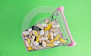 Shopping cart full of drug and medicine pills. pharmaceutical cost concept. medications in the cart. buying medicines. top view