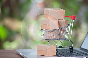 A shopping cart full of express parcels on an opened laptop keyboard