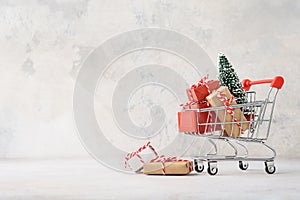 Shopping cart full of gift boxes and a Christmas tree