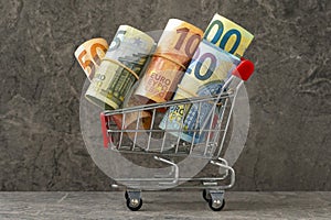 Shopping cart full of roll euro banknotes