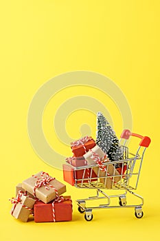 Shopping cart full of various gift boxes and a Christmas tree