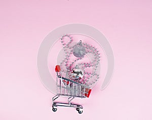 Shopping cart with gift or present and fir tree on snowy effect background. Christmas and New year sale concept. Vintage greeting