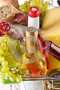 Shopping cart with groceries. Salami, grapes, bread, cheese and wine