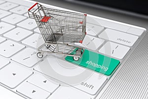 Shopping cart on laptop keyboard for e-commerce