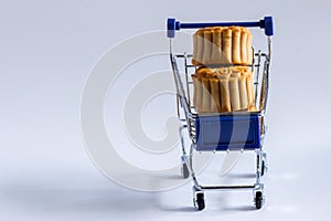 Shopping cart with mooncakes on white background