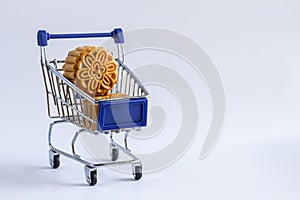 Shopping cart with mooncakes on white background