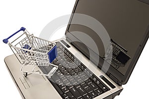 Miniature shopping cart on laptop computer