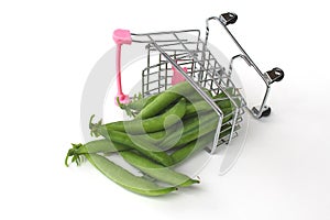 Shopping cart overturned on side with green peas