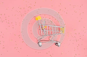 Shopping cart on pink festive background