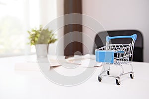 Shopping cart, receipts, notebook and calculator at office workplace. Home finances, investment, economy, saving money concept