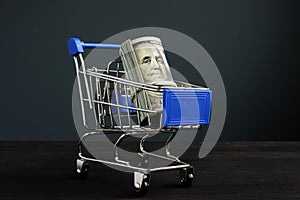 Shopping cart and roll of dollars. Money for loan and borrow cash