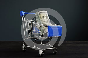 Shopping cart and roll of dollars. Money for loan and borrow cash photo