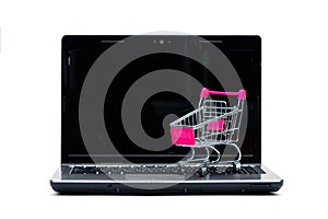 Shopping cart or supermarket trolley with laptop notebook isolated on white background, e-commerce and online shopping concept
