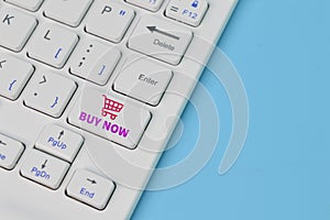 Shopping cart with text BUY NOW on laptop keyboard. Order in online and shopping on internet concept