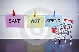 Shopping cart and text SAVE NOT SPEND. Concept, no consumerism.