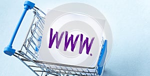 Shopping cart and text WWW on white paper note list. Shopping list concept on blue background