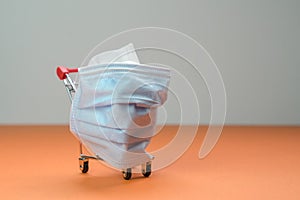 Shopping cart or trolley with medical face mask wrapped around it. Isolated