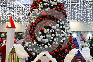 Shopping center with a Christmas tree decorated with beautiful balls, New Year`s toys, holiday decorations, winter holiday