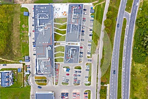 Shopping center or mall and parking for cars. City parking lot with different cars. Tree area. Parking zone top view with various