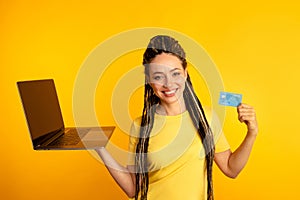 Shopping on computer. Smiling woman with laptop and credit card making purchase online.