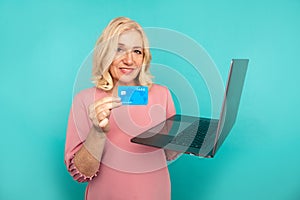 Shopping on computer. Smiling woman with laptop and credit card making purchase online.