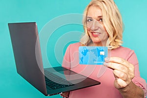 Shopping on computer. Smiling woman with laptop and credit card making purchase online.