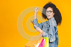 Shopping Concept - Portrait young beautiful african american woman smiling with colorful shopping bags and tablet computer