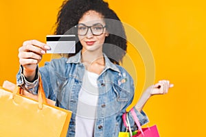 Shopping Concept - Portrait young beautiful african american woman smiling and joyful with colorful shopping bags and credit card