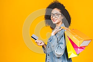 Shopping Concept - Portrait young beautiful african american woman smiling and joyful with colorful shopping bags and credit card