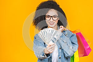 Shopping Concept - Portrait young beautiful african american woman smiling and joyful with colorful shopping bags and money