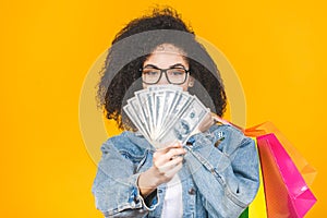 Shopping Concept - Portrait young beautiful african american woman smiling and joyful with colorful shopping bags and money