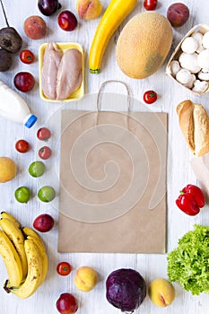 Shopping concept. Set of various groceries with paper bag on white wooden table, top view. Cooking food background. Flat lay of fr