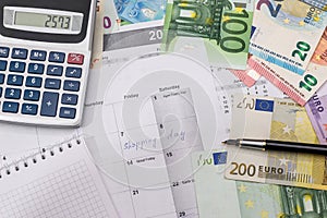 Shopping day written in the planner with euro bills,