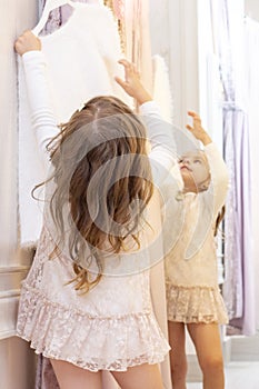 Shopping. discounts. little girl shopaholic. girl trying on a beautiful dress gently pink in the fitting room of the boutique. sho