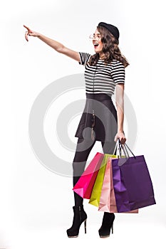 Shopping happy woman gesturing showing copy space at the side. Full length isolated on white background.