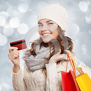 Shopping happy woman holding bags and credit card. Winter sales.