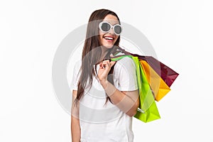 Shopping, leisure and lifestyle concept. Happy, joyful young feminine woman walking in store, buying new clothes and