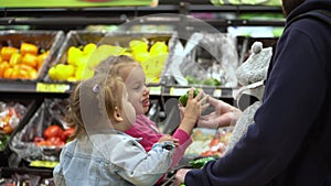 Shopping list food crises concepts. Father with Two daughters at Supermarket. Children sitting in cart. Kids Siblings