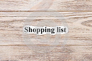 SHOPPING LIST of the word on paper. concept. Words of SHOPPING LIST on a wooden background
