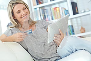 Shopping made easy. an attractive mature woman doing some online shopping at home.