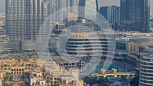 Shopping mall exterior with reataurants near fountain in Dubai downtown aerial morning timelapse, United Arab Emirates