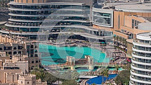 Shopping mall exterior with reataurants near fountain in Dubai downtown aerial timelapse, United Arab Emirates