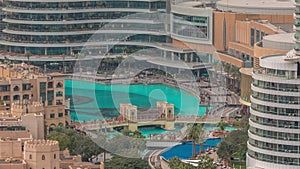 Shopping mall exterior with reataurants near fountain in Dubai downtown aerial timelapse, United Arab Emirates