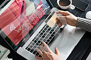 Shopping online concept. Woman holding gold credit card in hand and online shopping using on laptop at home.